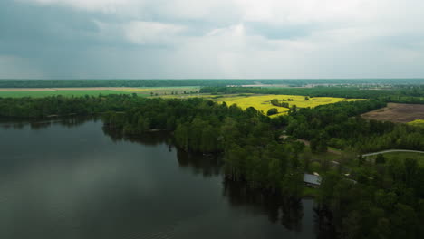 Reelfoot-lake-state-park-showcasing-the-expansive-lake-surrounded-by-lush-forests-and-vibrant-fields,-aerial-view