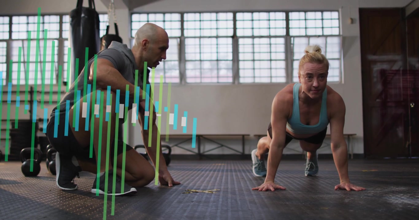 Trainer cueing trainee performing steady push-ups with pulsing bars over trainer for fitness
