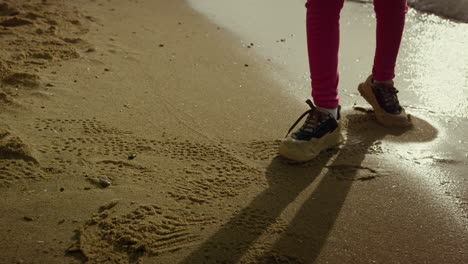 child walking sea beach. little girl legs running away crashing waves at seaside