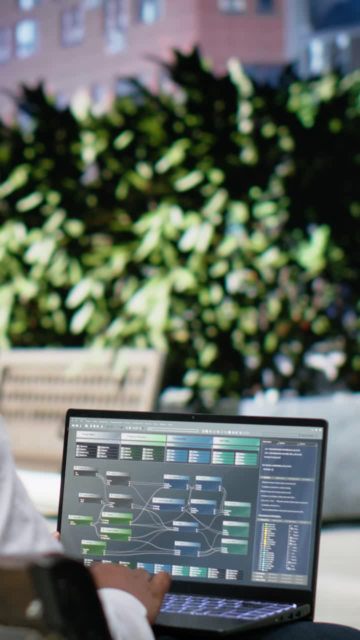 Vertical Video Black man works with indicators on laptop while sitting on a bench
