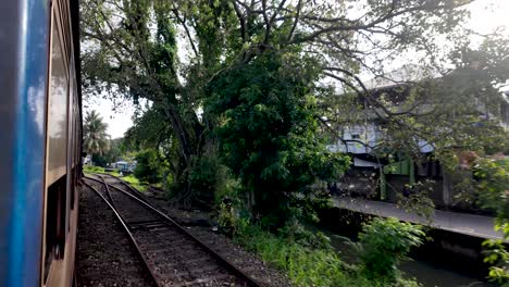 experience the serene beauty of sri lanka's lush landscape from a train moving slowly after departing kandy, showcasing the picturesque countryside and railway charm.