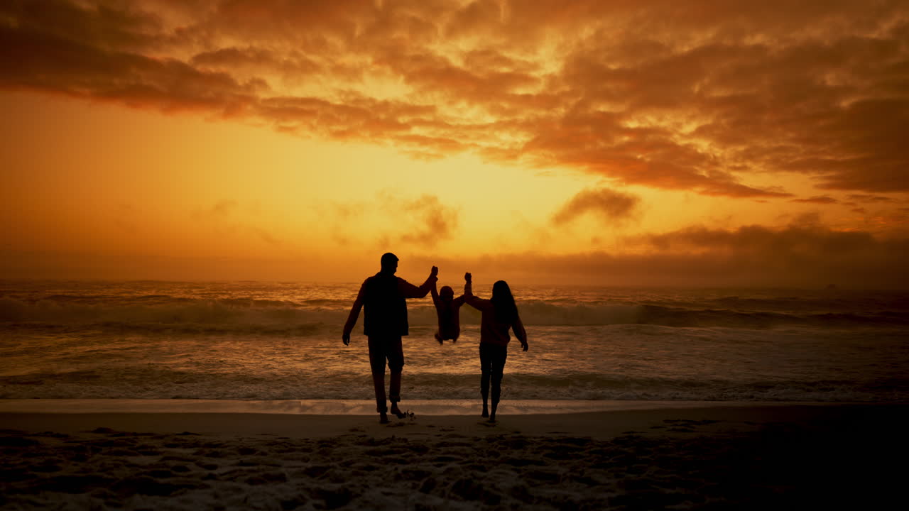 해가 지는 해변에서의 가족 실루