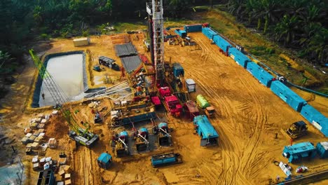 estructura cinematográfica de plataformas de perforación y reacondicionamiento en tierra y equipo de plataformas para la exploración y explotación de petróleo en medio de la jungla rodeada de palmeras durante la puesta de sol