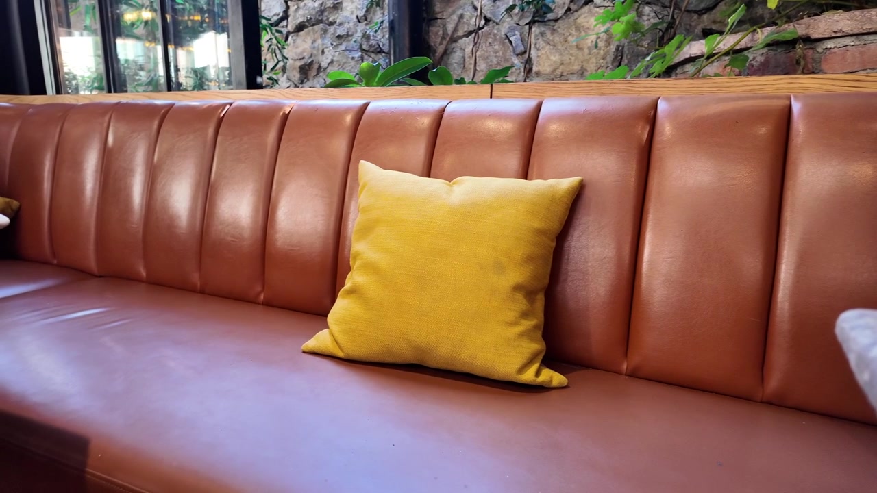 Yellow Cushion on Brown Leather Booth in Modern Restaurant