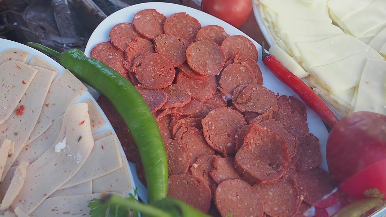 Primo piano di salumi affettati, formaggio e verdure fresche