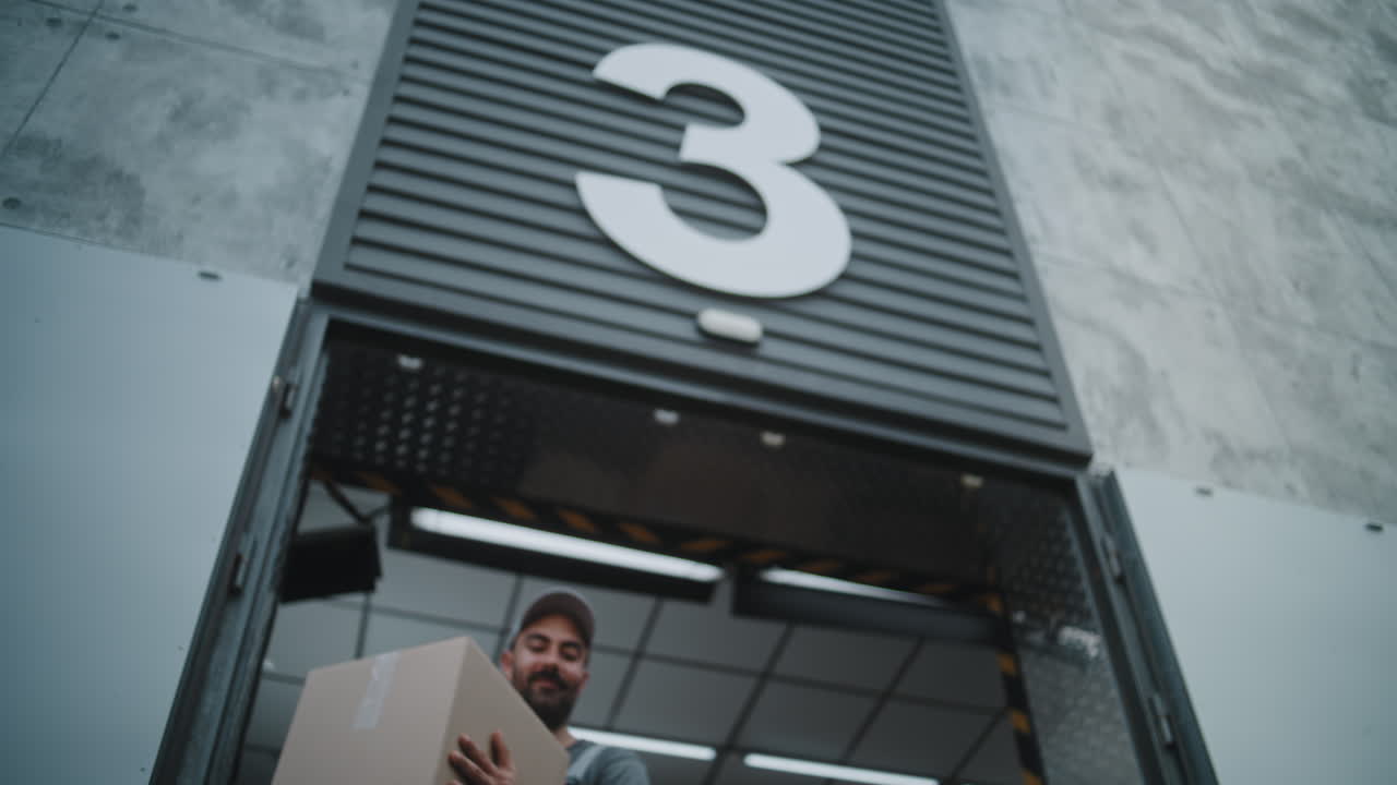 Workers handling a package at a warehouse entrance
