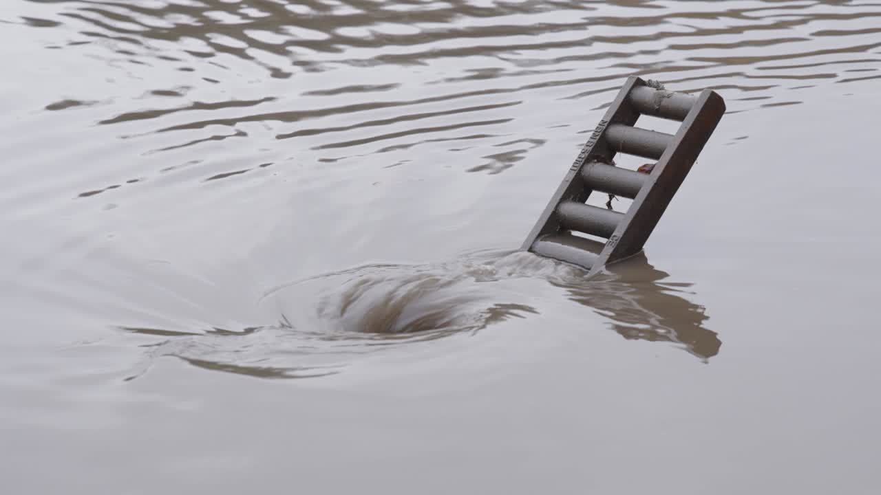 Floodwaters Flowing Into Open Sewer In The Street After Heavy Rain