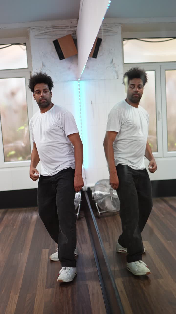 Man dancing in a studio with a mirror