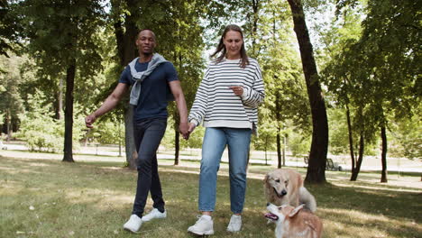 una pareja joven con mascotas en el parque.