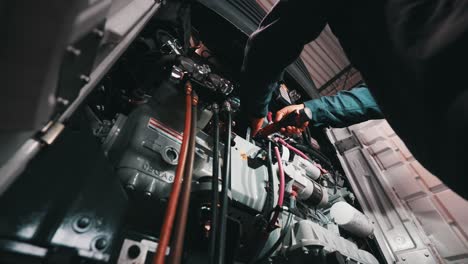 mechanic working on a reefer trailer, inserting an cordless electric screwdrive