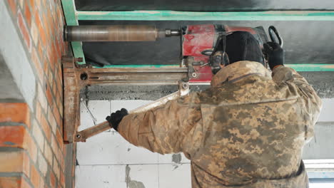 worker drills a wall with a powerful power tool makes holes for laying communications