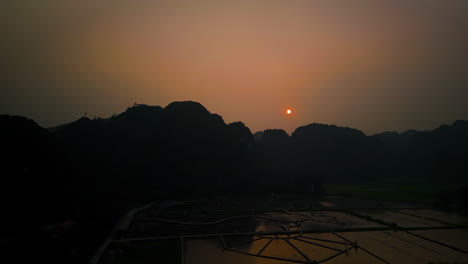 silhouettes of hang mua viewpoint at sunset in ninh binh, vietnam. aerial drone shot