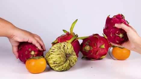 hands selecting fruits from a colorful arrangement