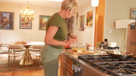 woman cooking eggs in her kitchen