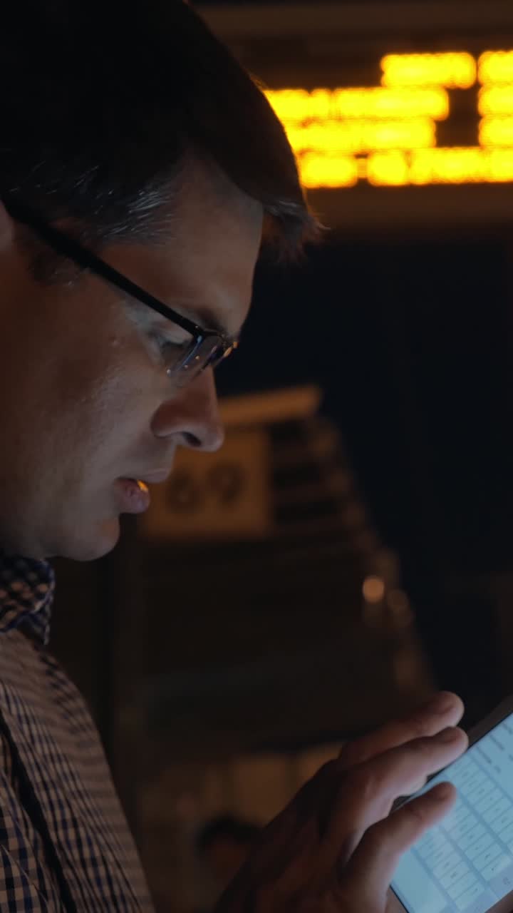 Focused Man in Glasses Using Tablet at Night