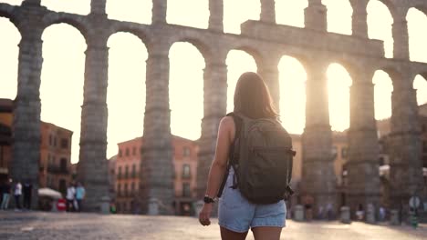 aqueduct of segovia visited by girl travelling to spain walking arround this artichetectural structure which is considered as a world heritage