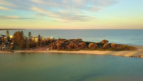 drone - aerial view of a turquoise color water lagoon at the golden sunrise sunset