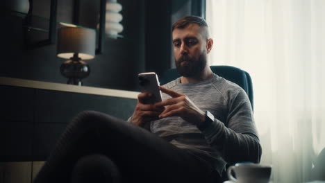 professional stock exchange broker analyzing real-time stocks and exchange market charts using smartphone, making investments. successful investment agent working in cozy office of financial agency.