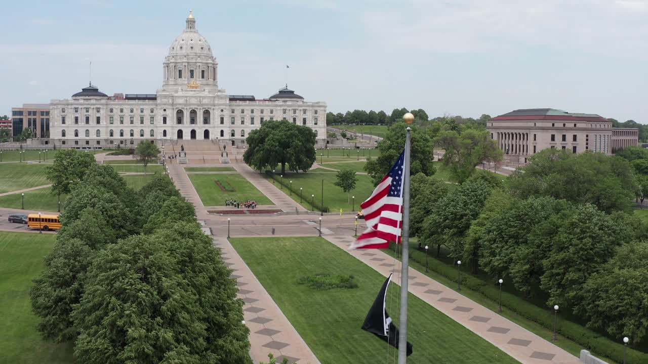 Nærbillede af indzoomende luftoptagelse af USA's flag foran Minnesota State Capitol-bygningen i Saint Paul, Minnesota.