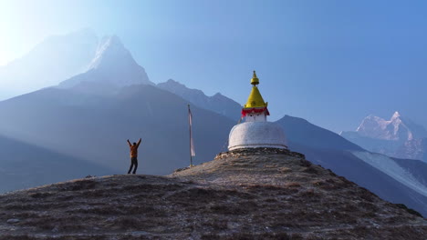 wide drone shot of a buddhist stupa in dingboche, khumbu, nepal. ama dablam rises in the backdrop as morning sunrays create a silhouette horizon, shaping a magical and spiritual himalayan experience
