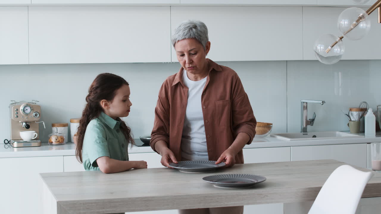 la abuela y la niña preparando la mesa