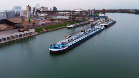 River-barges-docked-to-the-terminal-with-the-city-skyline-in-the-background-30fps-4k