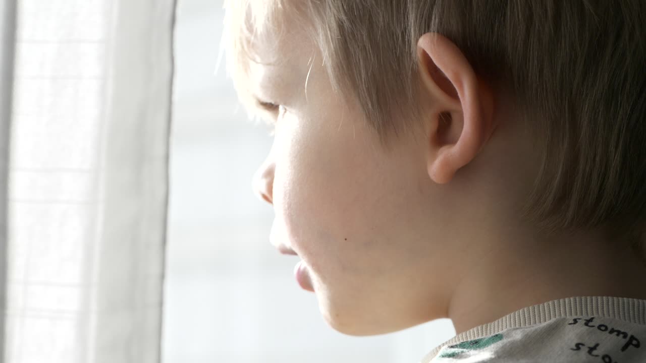 Coronavirus isolation, Close portrait shot of child face at home by the window during lockdown