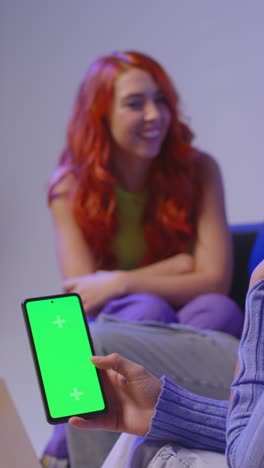 Vertical-Video-Of-Group-Of-Gen-Z-Friends-Sitting-On-Sofa-Eating-Home-Delivery-Takeaway-Pizza-And-Using-Mobile-Phones