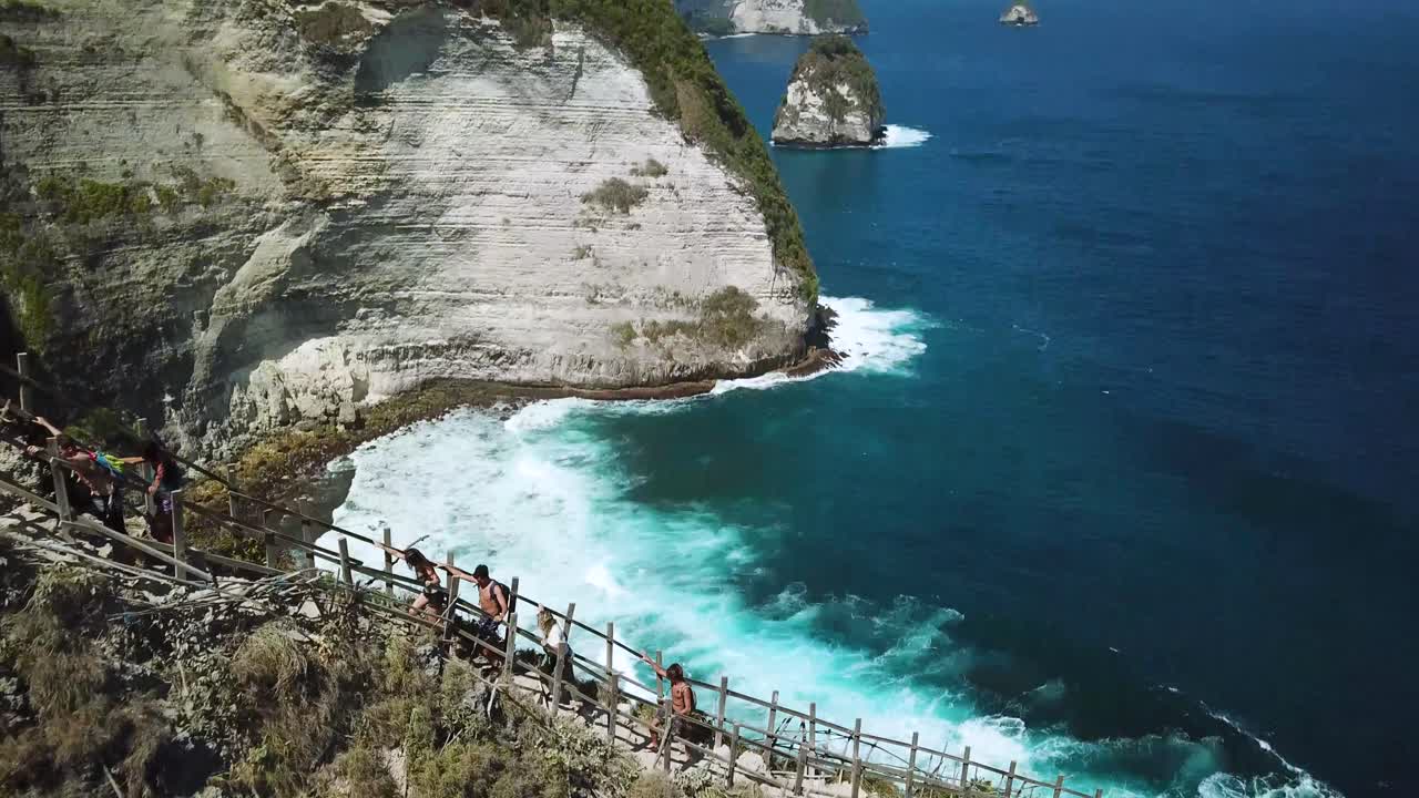 켈링킹 해변 위의 능선을 따라 하이킹하는 하이커 위로 날아가는 드론 샷