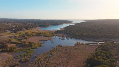 Flying-Over-Calm-Albufeira-Lagoon-Under-Sunlight,-Portugal