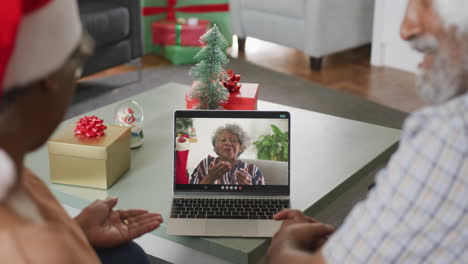feliz pareja de ancianos afroamericanos en videollamada con una amiga mayor en navidad