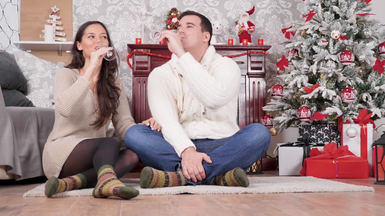 Couple celebrating Christmas with gifts and wine