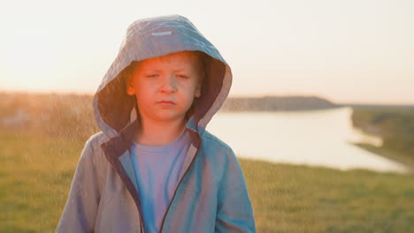 rainsoaked and weary boy on riverbank child heart aches with weight of abandonment with spirit