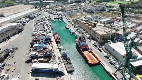 aerial drone shot flying sideways revealing several boats and ships in a busy boat yard