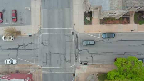 antena de arriba hacia abajo de la conducción de automóviles a través de la intersección en la calle en la ciudad de ee.uu.