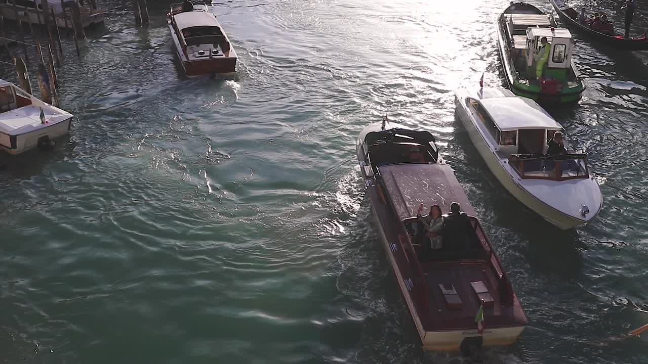 Cinematic slow motion of motorboats and gondolas in Venice famous canals.