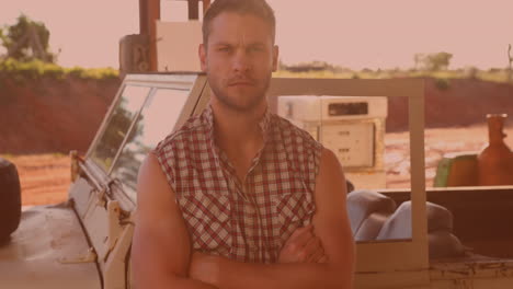 Portrait-of-caucasian-man-with-arms-crossed-standing-in-front-of-his-car-outdoors