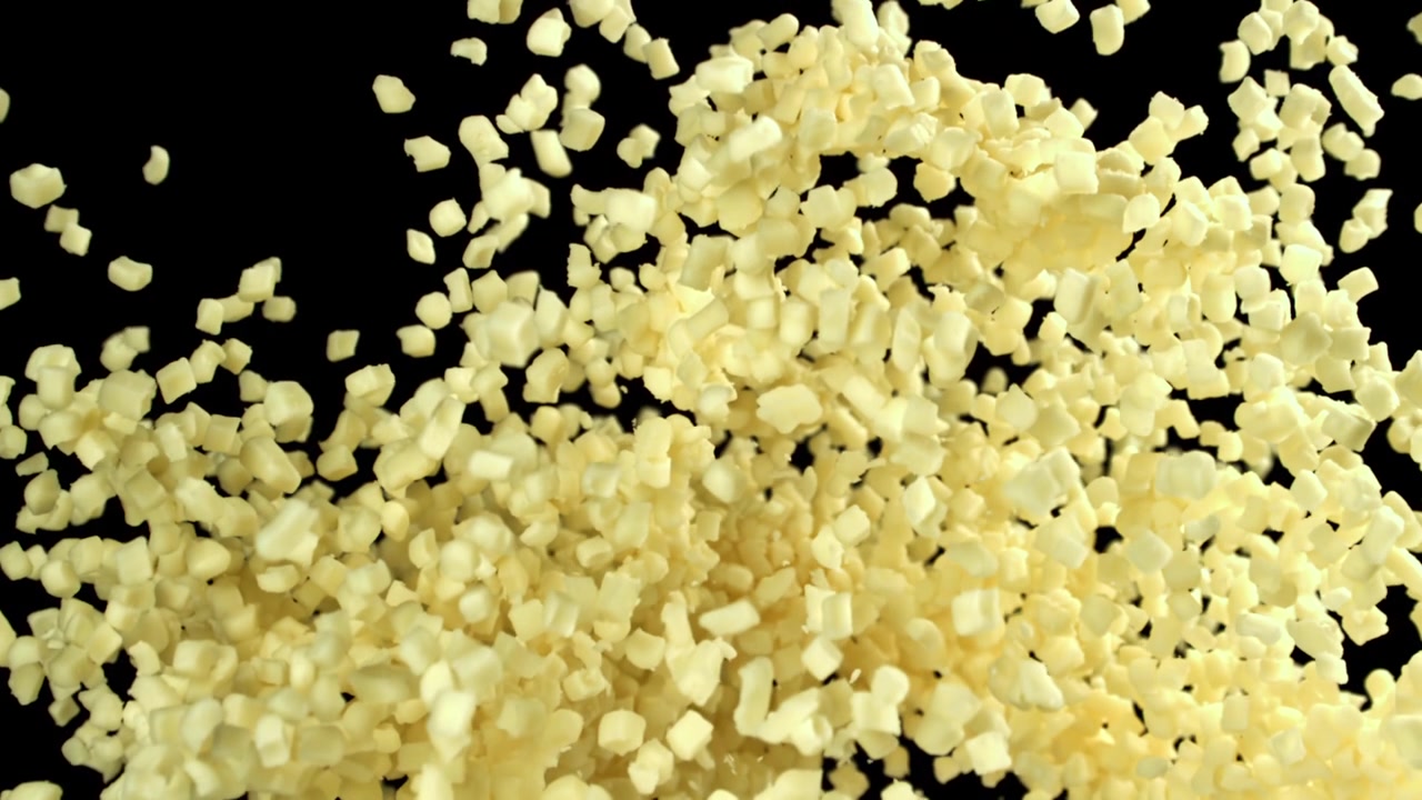 Cubetti di cibo giallo a dadini in caduta al rallentatore