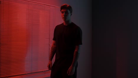 man in a dimly lit room with red light