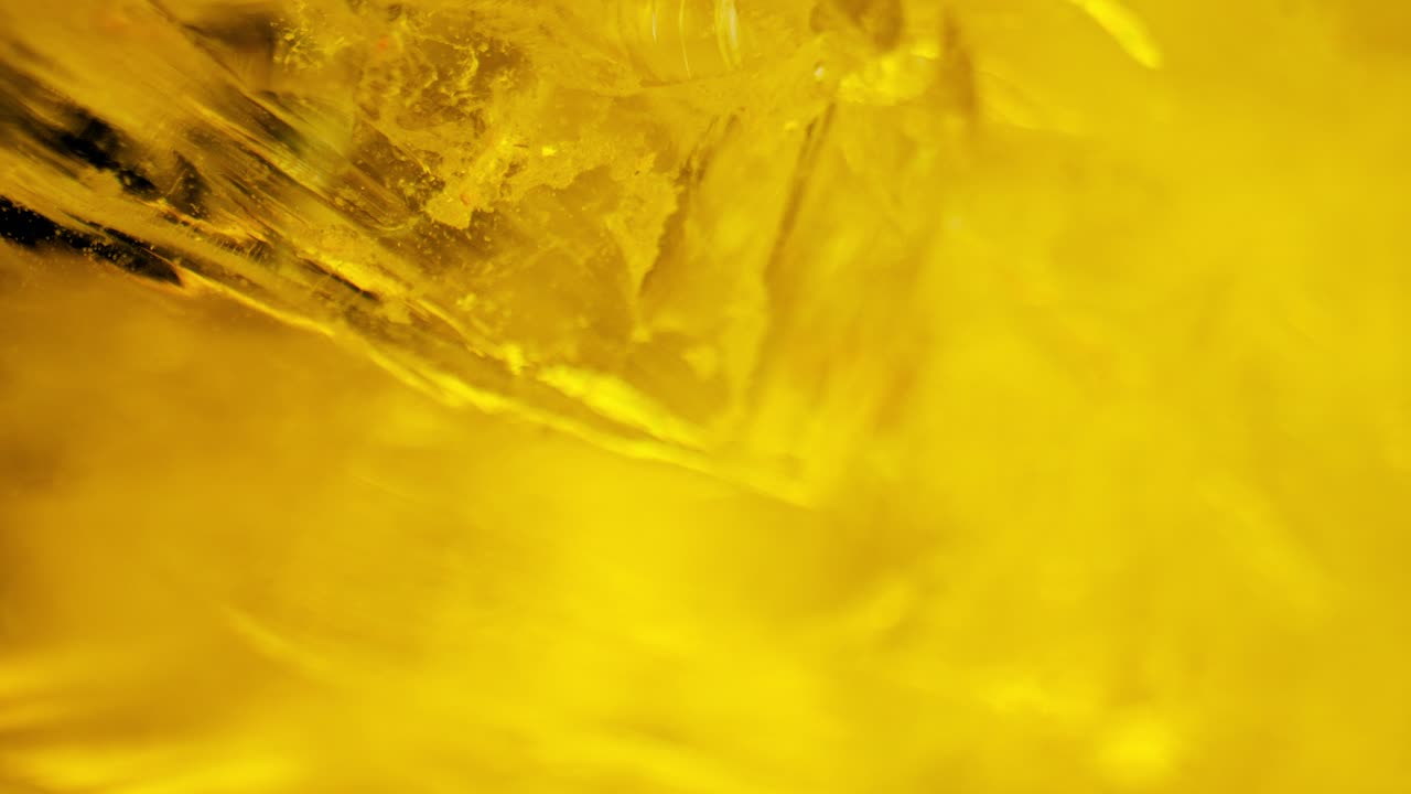 cuarzo cristalino que brilla bajo la luz amarilla, capturado a través de una panorámica suave y una lente macro para obtener detalles fascinantes.