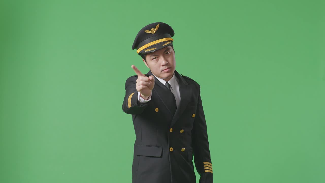 Asian Man Pilot Pointing At You And Disapproving With No Index Finger Sign In The Green Screen Background Studio