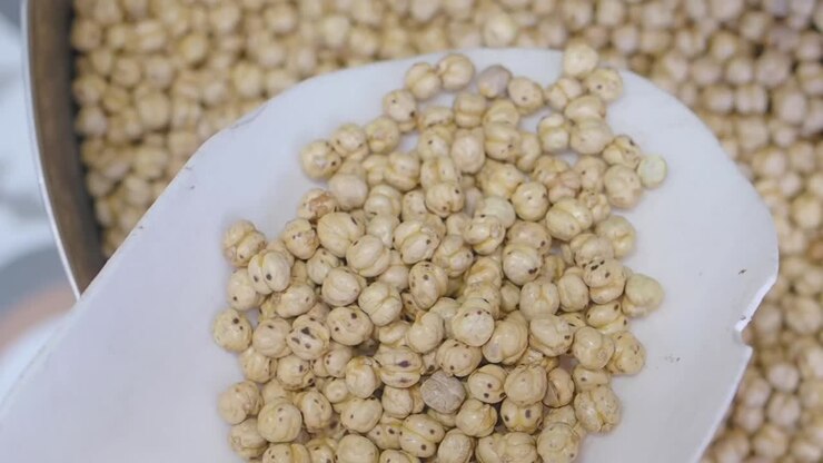 A close-up of roasted chickpeas being scooped