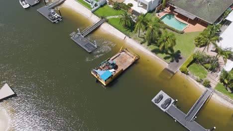 barge operates near houses along river canal