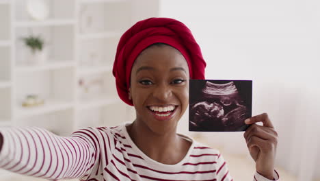 happy pregnant woman showing ultrasound photo
