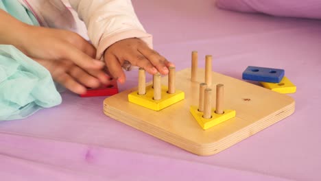 toddler playing with wooden shape puzzle