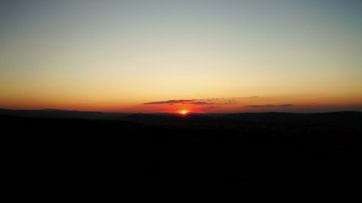 Tramonto su una valle in controluce nella campagna.