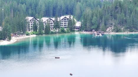 Peaceful-aerial-view-of-Pragser-Wildsee-turqoise-water,-lakeside-hotel-backdrop