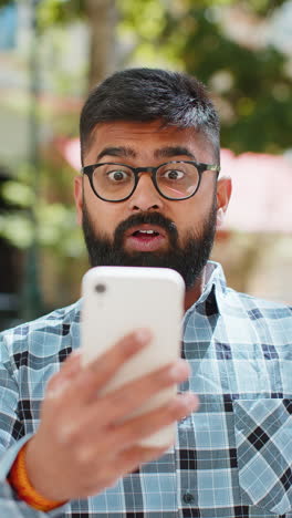 Excited-happy-Indian-young-man-use-smartphone-celebrating-win-good-message-news-in-city-street