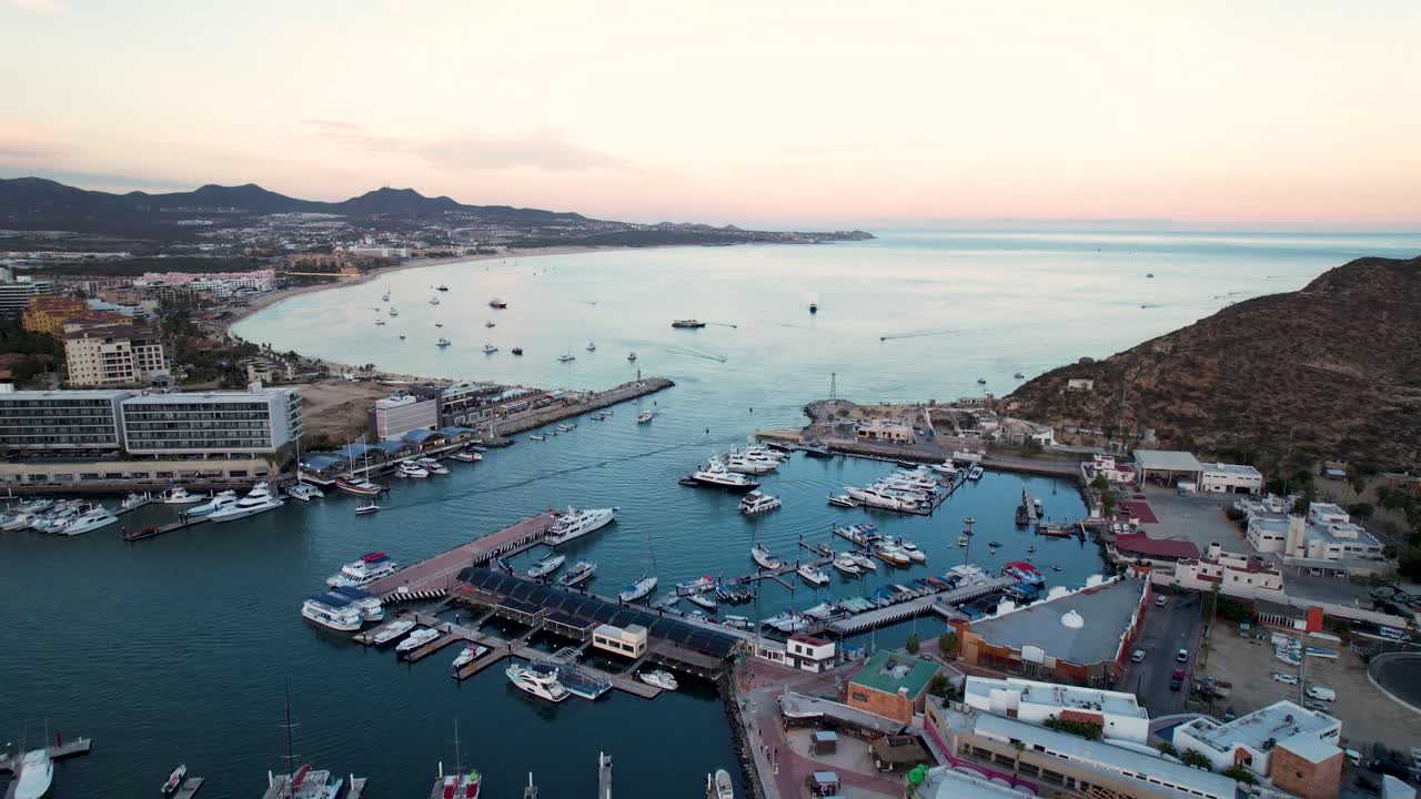 A breathtaking 4k drone reveal of Cabo San Lucas Bay at sunset, capturing the coastline, ocean, and vibrant sky