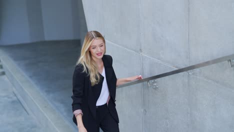 businesswoman walking by modern concrete wall